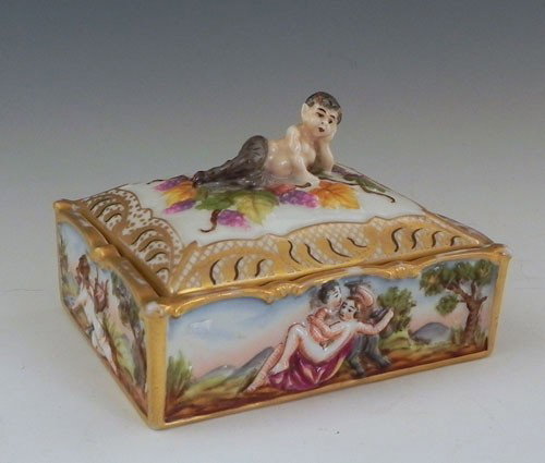 Capodimonte Dresser Box, c. 1900, marked Germany,: Capodimonte Dresser Box, c. 1900, marked Germany, the handle of the lid with a reclining figure of Pan, the sides with relief classical figures, H.- 2 3/4 in., W.- 4 in., D.- 3 1/4 in.