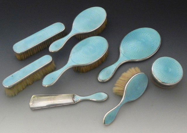Eight Piece Enamel Dresser Set, early 20th c., wit: Eight Piece Enamel Dresser Set, early 20th c., with a maker's mark of CG, consisting of a covered glass powder jar, 3 hair brushes, 2 clothes brushes, a shoehorn, and a hand mirror. (8 Pcs.)