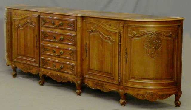 Large Louis XV Style Carved Cherry Sideboard, 20th: Large Louis XV Style Carved Cherry Sideboard, 20th c., with a central bank of drawers, flanked by floral carved fielded panel doors and convex end doors, over floral carved skirts, on cabriole legs to