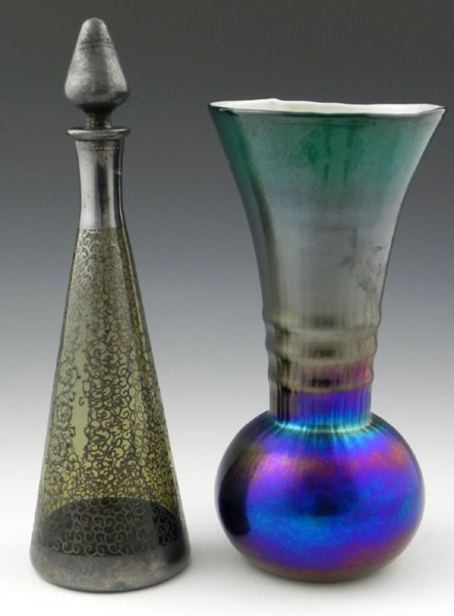 Two Pieces of Art Glass, early 20th c, a silver de: Two Pieces of Art Glass, early 20th c, a silver depose olive green decanter and stopper, and a tall blue Aurene glass vase.