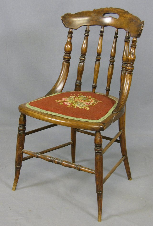 American Carved Faux Grained Walnut Side Chair, c.: American Carved Faux Grained Walnut Side Chair, c. 1890, the arched back with a hand hold, over spindles to a needlepoint upholstered seat, the whole on splayed legs joined by turned stretchers, H.- 3