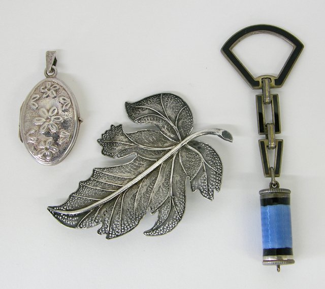 Three Metal Pieces, a sterling locket, a twisted w: Three Metal Pieces, a sterling locket, a twisted wire leaf form brooch, and an Art Deco enamel lipstick on chain.(3 Pcs.)