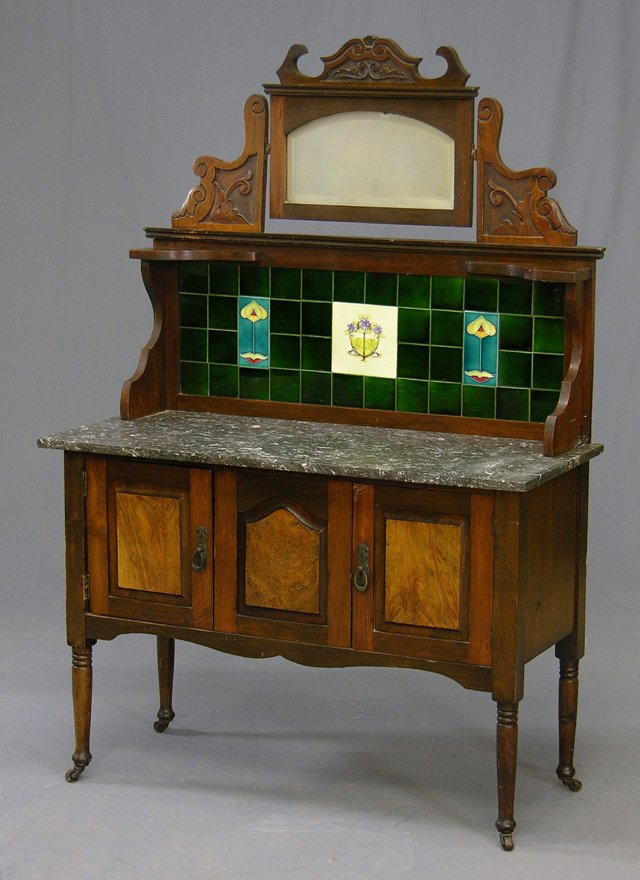 English Carved Mahogany Marble Top Washstand, c. 1: English Carved Mahogany Marble Top Washstand, c. 1900, the back splash with a central tilting beveled mirror over green ceramic tiles, on a base with a highly figured gray marble over two cupboard doo