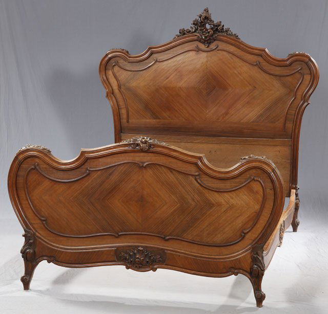 French Louis XV Style Carved Mahogany Bed, c. 1920: French Louis XV Style Carved Mahogany Bed, c. 1920, the arched headboard with a scroll and floral crest over a crotched panel back, the footboard with a central floral and scroll carving over crotched