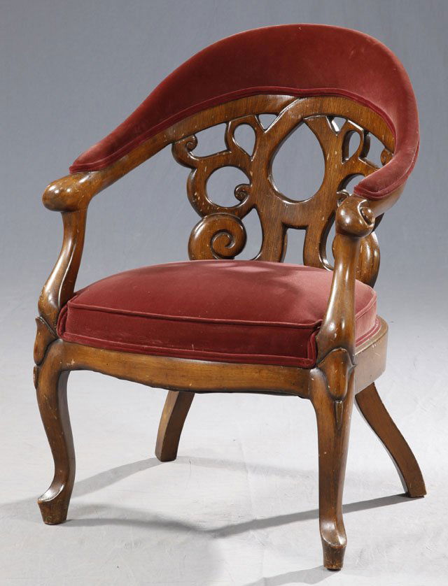 After John Henry Belter, Carved Oak Upholstered Ar: After John Henry Belter, Carved Oak Upholstered Armchair, early 20th c., with an upholstered crst over apierce carved back, to scrolled arms, to an upholstered seat, on saber legs to French toes, H.-