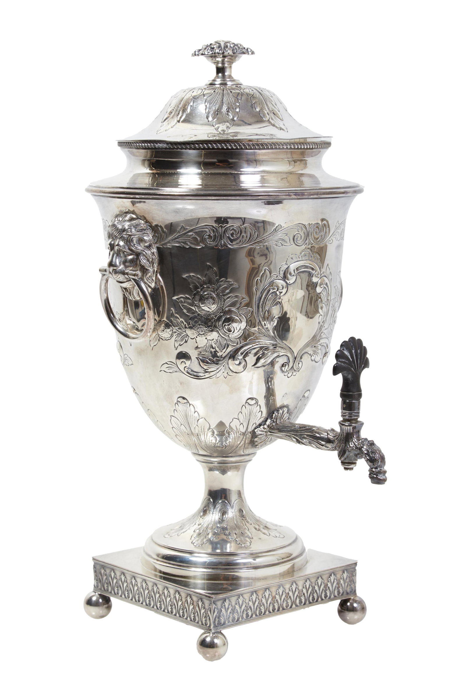 English Silverplate Hot Water Urn, 19th c., H.- 19 1/4 in., W.- 10 in., D.- 11 in.: English Silverplate Hot Water Urn, 19th c., with floral and scroll repousse decoration, and lions' head ring handles, on a socle support to a square relief decorated base on ball feet, H.- 19 1/4 in.,
