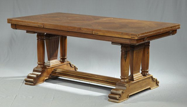 French Carved Oak Draw Leaf Table, late 19th c., w: French Carved Oak Draw Leaf Table, late 19th c., with a parquetry inlaid top, on trestle supports with tapered and circular columns, joined by a stepped rectangular stretcher, H.- 28 in., W.- Closed-