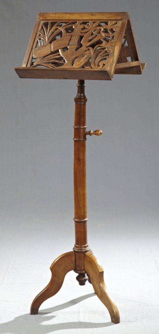 Carved Walnut Adjustable Double Music Stand, late : Carved Walnut Adjustable Double Music Stand, late 19th c., the pierce carved sheet music holders with leaf and musical motifs, on a turned support to flat tripodal cabriole legs, H.- 49 in., W.- 15 1/