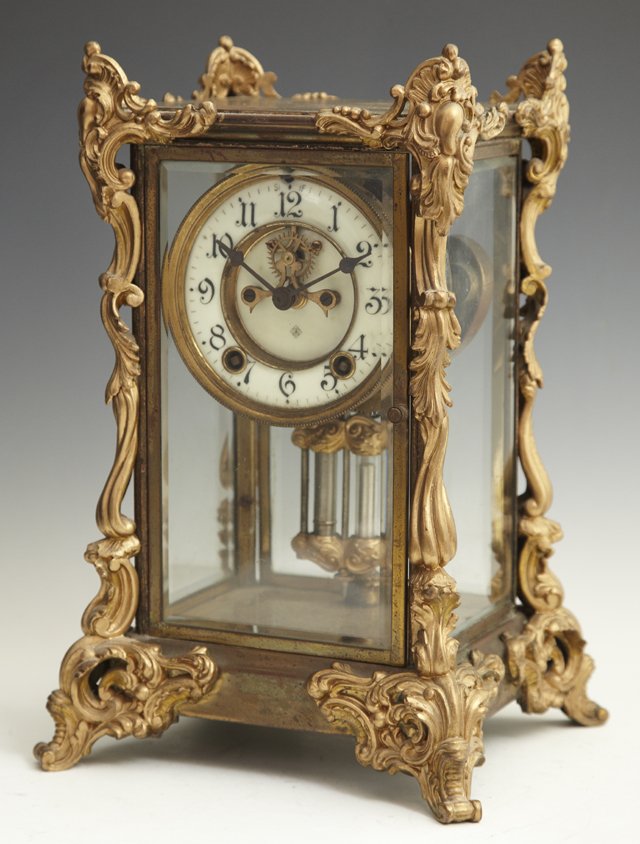 Ansonia Brass and Glass Crystal Regulator Clock, l: Ansonia Brass and Glass Crystal Regulator Clock, late 19th c., the edges with relief brass scroll and leaf decoration, on pierced relief leaf and scroll feet, time and strike, with a faux mercury pend