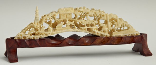 Japanese Meiji Elaborately Carved Tusk Ivory Grou: Japanese Meiji Elaborately Carved Tusk Ivory Group, late 19th c., depicting figures by a shrine in a wooded landscape, presented on a carved hardwood stand, H.- 2 in., W.- 7 1/2 in., D.-. 1 1/4 in.