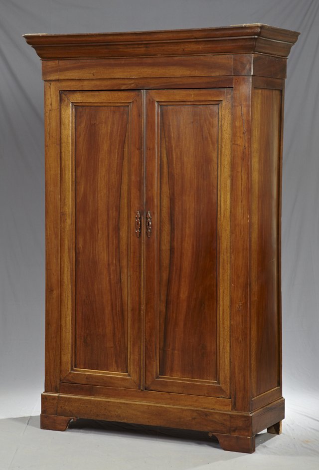 Louis Philippe Carved Walnut Armoire, c. 1850, th: Louis Philippe Carved Walnut Armoire, c. 1850, the ogee crown over double doors with wood escutcheons, on plinth base on bracket feet, H.- 87 1/2 in., W.- 56 in., D.- 22 in.