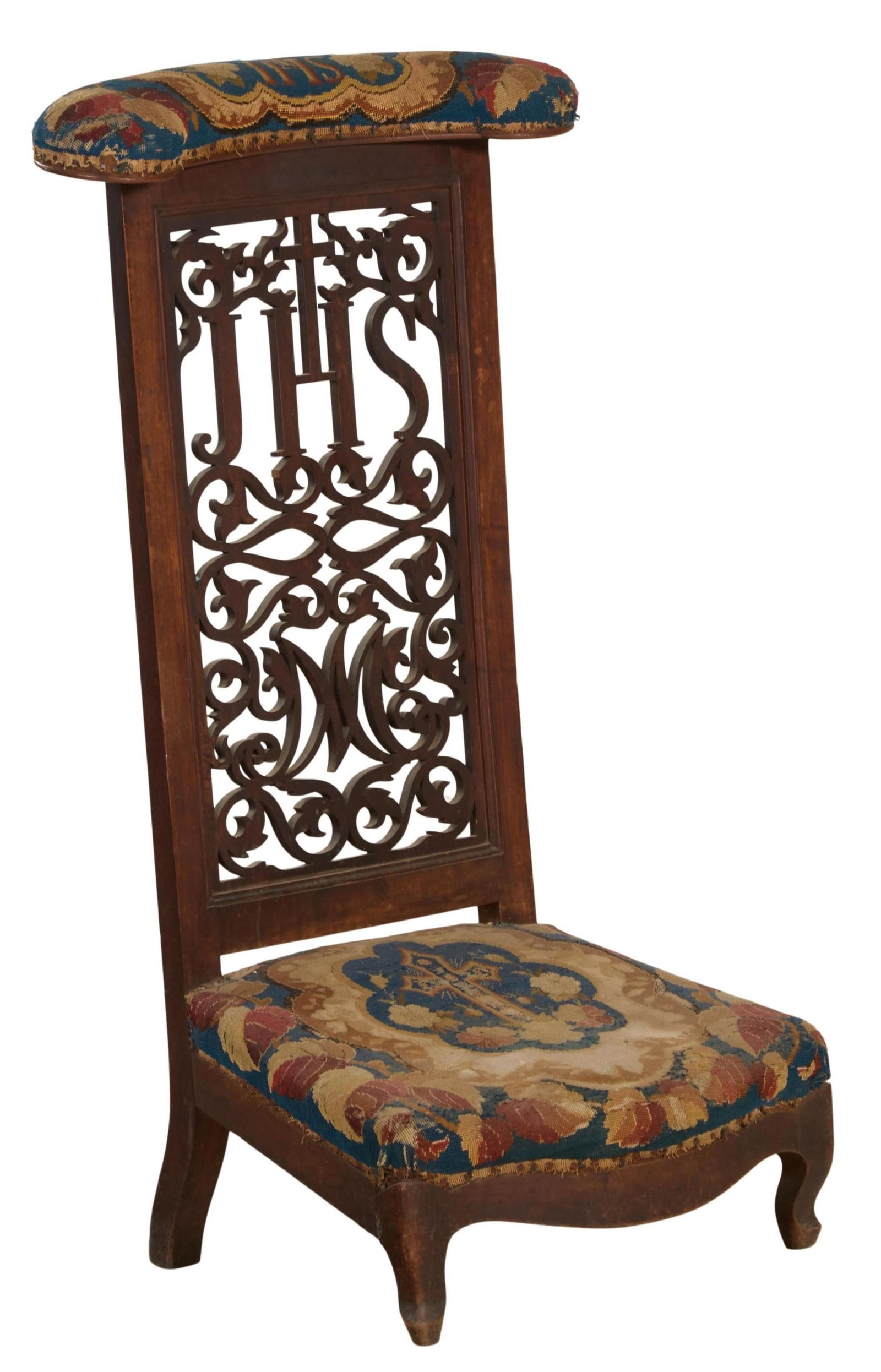 French Provincial Carved Walnut and Needlepoint Prie Dieu, mid 19th., H.- 42 in., W.- 22 in., D.- 18: French Provincial Carved Walnut and Needlepoint Prie Dieu, mid 19th., the oblong padded armrest above, pierced fret carved standard with cross, JHS and Mary cyphers, decorations with scrolling foliate