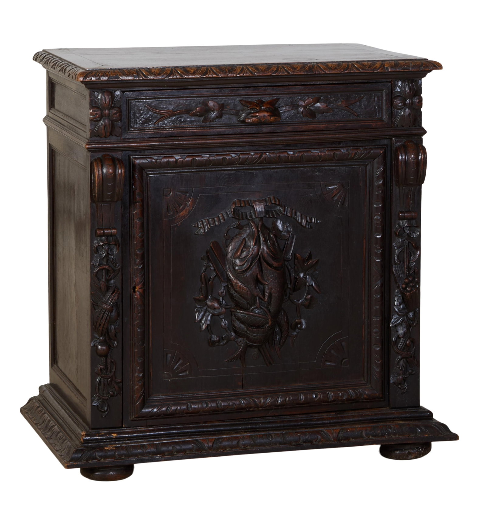 French Henri II Style Carved Oak Confiturier, 19th c., H.- 38 in., W.- 34 1/4 in., D.- 20 in.: French Henri II Style Carved Oak Confiturier, 19th c., the top with carved moulded edge, over a frieze drawer with masque handle, above a cabinet door with relief carved nature morte trophy panel, fla