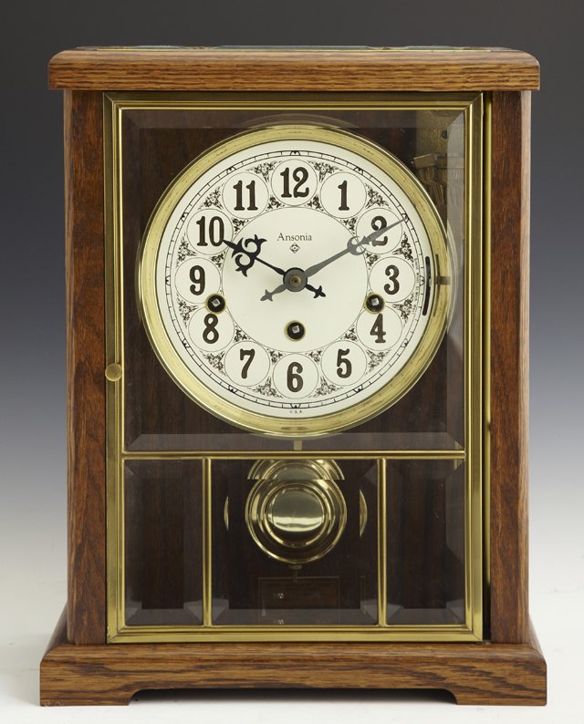 Unusual Carved Oak "Gold Medallion" Mantel Clock, 20th : Unusual Carved Oak "Gold Medallion" Mantel Clock, 20th c., by the Ansonia Clock Co., Lynwood, WA, time and strike, the front and sides with beveled glass panels, H.- 14 3/4 in., W.- 11 3/8 in., D.- 6