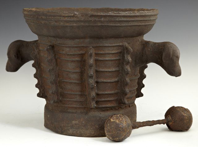 Large Spanish Cast Iron Mortor, 16th c., with a ridged : Large Spanish Cast Iron Mortor, 16th c., with a ridged rim, the sides cast with eight knopped buttresses, eight relief bands and a pair of handles with dog heads, with associated pestle, H.- 10 1/2 in