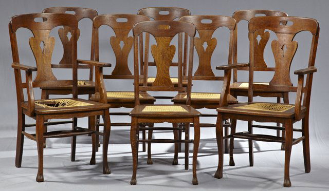 Set of Eight (6 + 2) Carved Oak Dining Chairs, c. 1910,: Set of Eight (6 + 2) Carved Oak Dining Chairs, c. 1910, the back with hand holes over pierced shaped splats, to caned seats, on tapered legs on paw feet, joined by turned stretchers, the cane on three