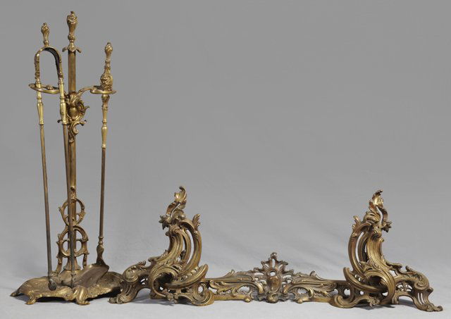 Brass Louis XV Style Fireplace Set, early 20th c., cons: Brass Louis XV Style Fireplace Set, early 20th c., consisting of a pair of pierced swirling chenets joined by a pierced fire fender, together with a matching firetool set consisting of a shovel and to