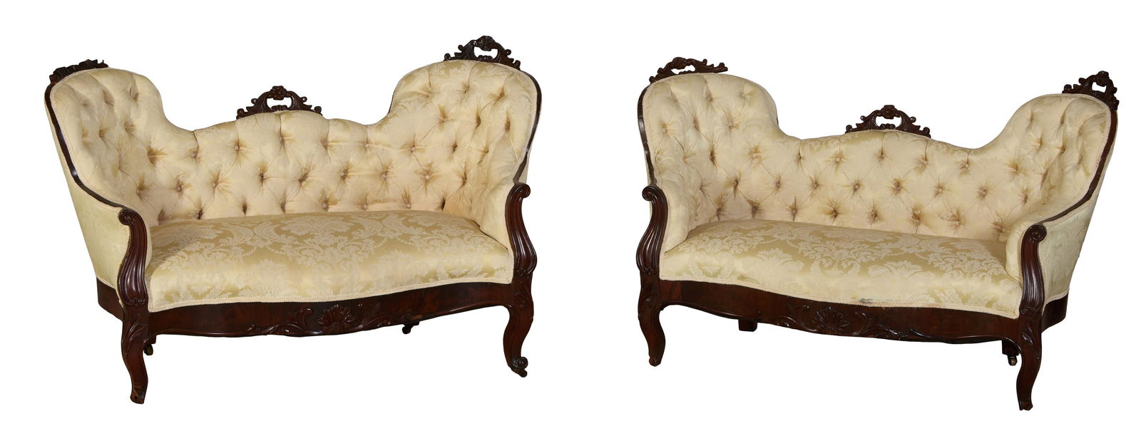 Pair of American Victorian Carved Mahogany Window Settees, mid 19th c., Each- H.- 33 1/2 in., W.- 53: Pair of American Victorian Carved Mahogany Window Settees, mid 19th c., the pierced acanthus floral crest, low back with arched tufted backs, scrolled arms into acanthus carved cabriole legs joined by
