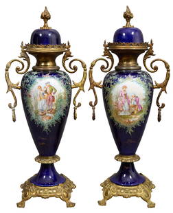 Pair of Sevres Style Ormolu Mounted Cobalt Vases, 20th c., Each- H.- 23 in., W.- 9 in., D.- 7 in. (2: Pair of Sevres Style Ormolu Mounted Cobalt Vases, 20th c., the flame finialed domed cobalt blue tops over handled metal vase tops, baluster centers with romantic courting scene cartouche, lobbed waist