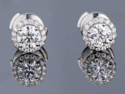 Pair of Tiffany & Co. Platinum Diamond Halo Stud Earrings, Total Diamond Wt.- 0.97 carats: Pair of Tiffany & Co. Platinum Diamond Halo Stud Earrings, each stud mounted with an internally flawless app. 0.5 carat diamond atop a border of 12 tiny round diamonds, Total Diamond Wt.- 0.97 carats,