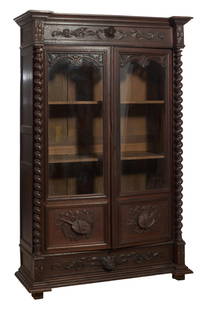French Henri II Style Carved Oak Bibliotheque, late 19th c., H.- 88 1/2, W.- 55 in., D.- 20 1/2 in.: French Henri II Style Carved Oak Bibliotheque, late 19th c., the stepped moulded cornice with projected blocked corners, relief carved shield with acanthus foliate carving, two glazed doors with