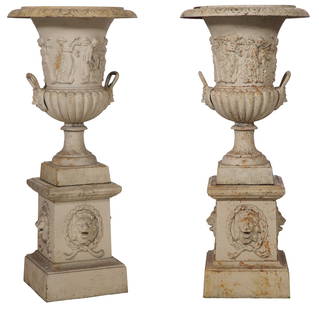 Pair of Iron Garden Urns on Stands, 20th c., H.- 64 in., W.- 21 in., D.- 18 1/2 in. (2 Pcs.): Pair of Iron Garden Urns on Stands, 20th c., the flared rims over maiden circled body, lower lobbed section with handles, on a plinth base with lion bust in garland, H.- 64 in., W.- 21 in., D.- 18
