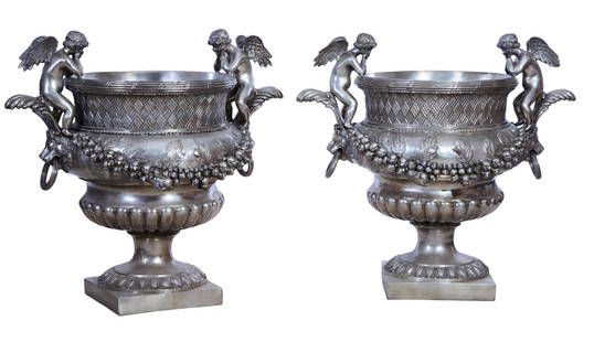 Pair of Extra Large Silvered Metal Cherub Jardinieres, 20th c., H.- 54 in., W.- 58 in., D.- 42 in.: Pair of Extra Large Silvered Metal Cherub Jardinieres, 20th c., the opposing gazing cherubs over garland swaged lobbed body flanked by lion bust handles, on a socle base with anthemion surround on