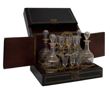 French Ebonized Wood Tantalus, late 19th. c., Box- H.- 10 in., W.- 13 in., D.- 9 1/2 in. (19 Pcs.): French Ebonized Wood Tantalus, late 19th. c., the brass string inlaid ebonized case with the hinged fall front, opening to reveal four copper wheel cut and gilt- banded decanters, with conforming stop