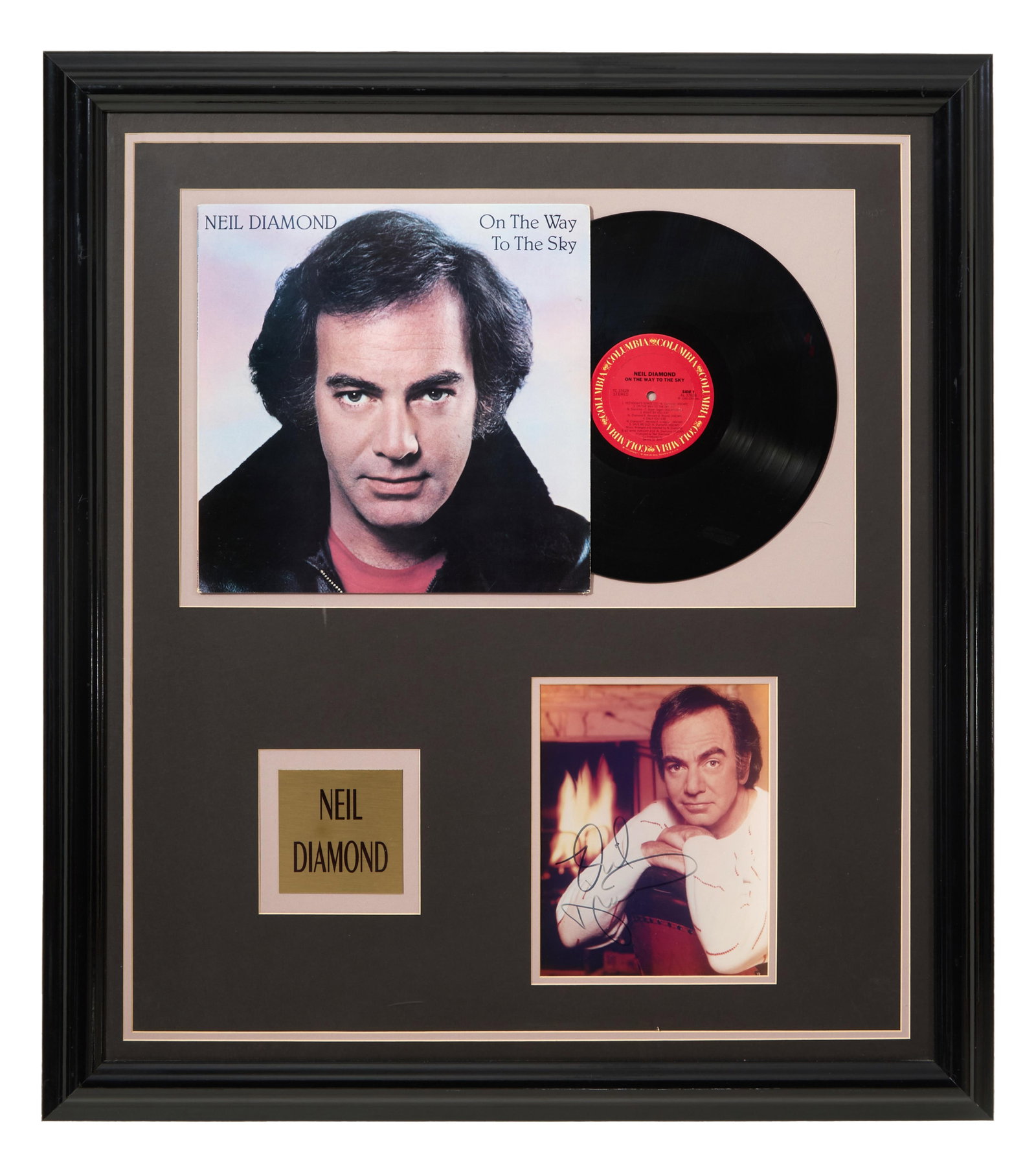 Neil Diamond "On the Way to the Sky" Autographed Memorabilia, Overall- H.- 34 1/2 in., W.- 30 1/2: Neil Diamond "On the Way to the Sky" Autographed Memorabilia, with Columbia Records LP, album cover, signed color photo of Diamond, and a gilt plaque, presented in a black frame with plexiglass, Overa