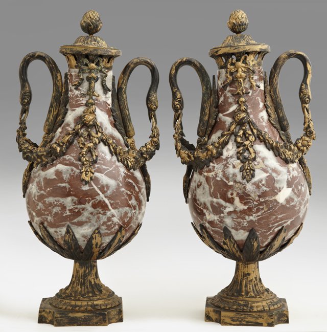 Pair of Empire Style Bronze and Marble Covered Garnitur: Pair of Empire Style Bronze and Marble Covered Garniture Urns, 20th c., the highly figured brown marble with gilt swans' head handles and floral garlands, on socle supports to domed shaped square base