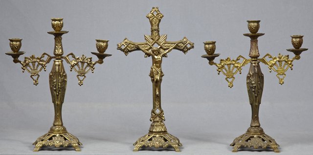 Three-Piece Brass Altar Set, early 20th c., composed of: Three-Piece Brass Altar Set, early 20th c., composed of a crucifix, and pair of matching three-light candelabra modeled as cranes, with their bills resting on their breasts, all on matching square ret