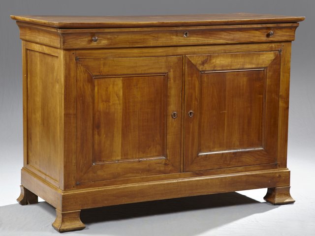 Louis Philippe Carved Cherry Sideboard, c. 1850, the ro: Louis Philippe Carved Cherry Sideboard, c. 1850, the rounded corner top over a long frieze drawer above double cupboard doors, on a plinth base on ogee block feet, H.- 39 3/4 in., WE.- 55 1/2 in., D.-