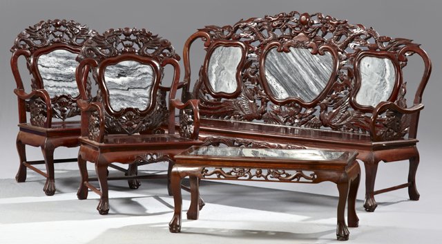 Oriental Carved Mahogany Four Piece Marble Inlaid Parlo: Oriental Carved Mahogany Four Piece Marble Inlaid Parlor Suite, 20th c., consisting of a settee, two armchairs, and a coffee table, the settee with elaborate pierce carved dragon crests over three hig