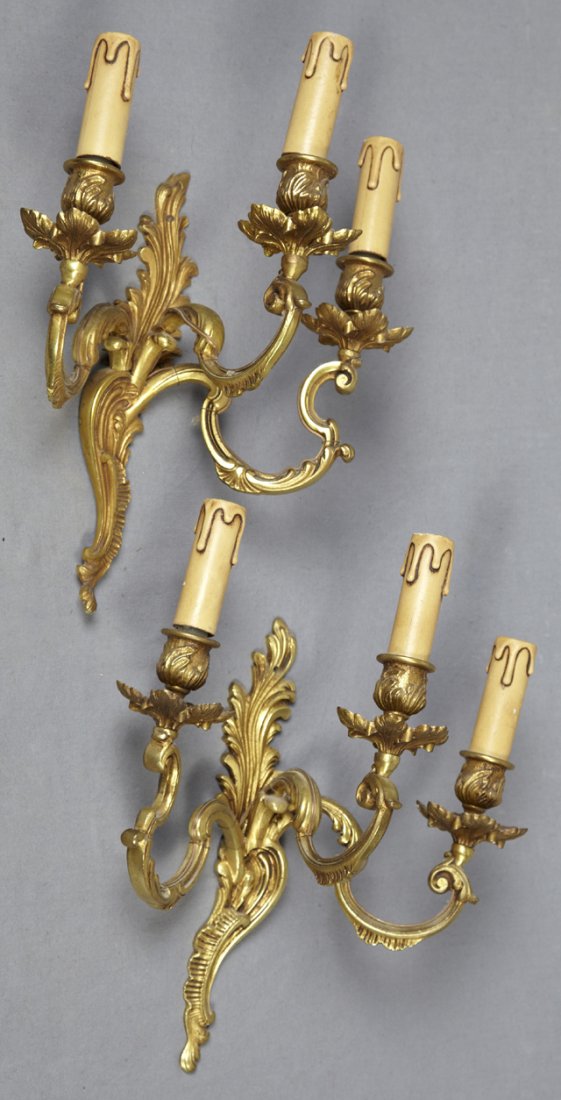 Pair of Louis XV Style Bronze Three Light Wall Sconces,: Pair of Louis XV Style Bronze Three Light Wall Sconces, 19th c., with relief candle cups and floriform bobeches on scrolled arms to a leaf form back plate, now electrified, H.- 13 7/8 in., W.- 12 in.,