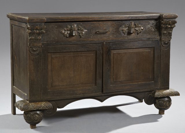 Dutch Carved Oak Sideboard, 19th c., the ogee edge bloc: Dutch Carved Oak Sideboard, 19th c., the ogee edge block form top over a large frieze drawer with hoof form handles, over double cupboard doors flanked by pilasters with leaf form capitals, on carved 