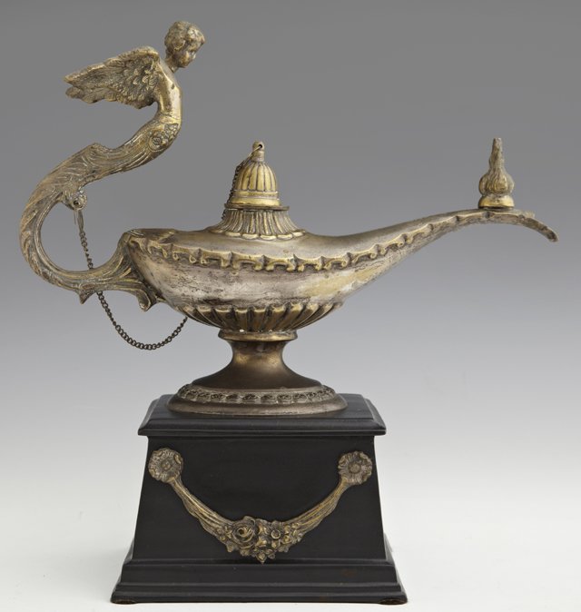 Large Empire Style Brass Aladdin's Lamp Table Cigar Lig: Large Empire Style Brass Aladdin's Lamp Table Cigar Lighter, 20th c., with a winged putto handle, on a tapering black patinated metal base with applied floral garlands, H.- 13 3/8 in., W.- 12 3/4 in.,