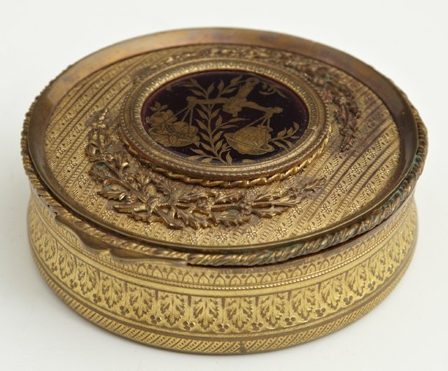 French Circular Bronze Trinket Box, 19th c., the lid wi: French Circular Bronze Trinket Box, 19th c., the lid with engine turned decoration and applied leaf and berry garlands, with a central crimson enamel plaque depicting a balance scale with fruit, H.- 1