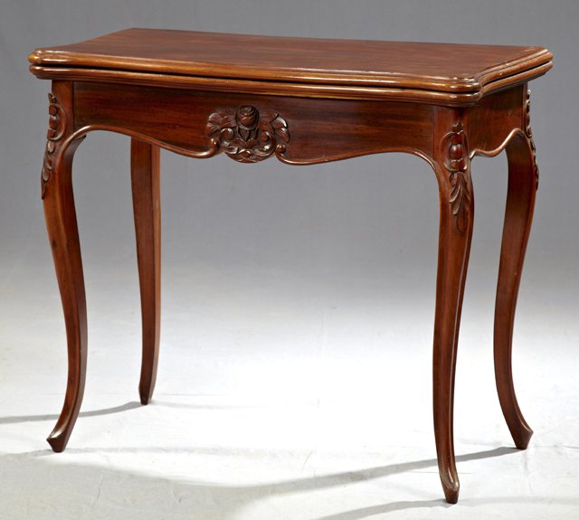 Napoleon III Carved Mahogany Games Table, c. 1870, the: Napoleon III Carved Mahogany Games Table, c. 1870, the bow front stepped edge top over shaped skirts with central floral carving, on leaf carved cabriole legs, the interior with an inset gilt tooled b