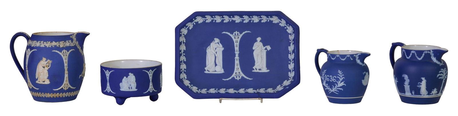 Group of Five Dark Blue Wedgwood Pieces, 20th c., Largest Pitcher- H.- 5 3/4 in., W.- 7 in., D.- 5: Group of Five Dark Blue Wedgwood Pieces, 20th c., consisting of an 1883 serving tray, three milk pitchers, and a small planter, Largest Pitcher- H.- 5 3/4 in., W.- 7 in., D.- 5 in. (5 Pcs.)