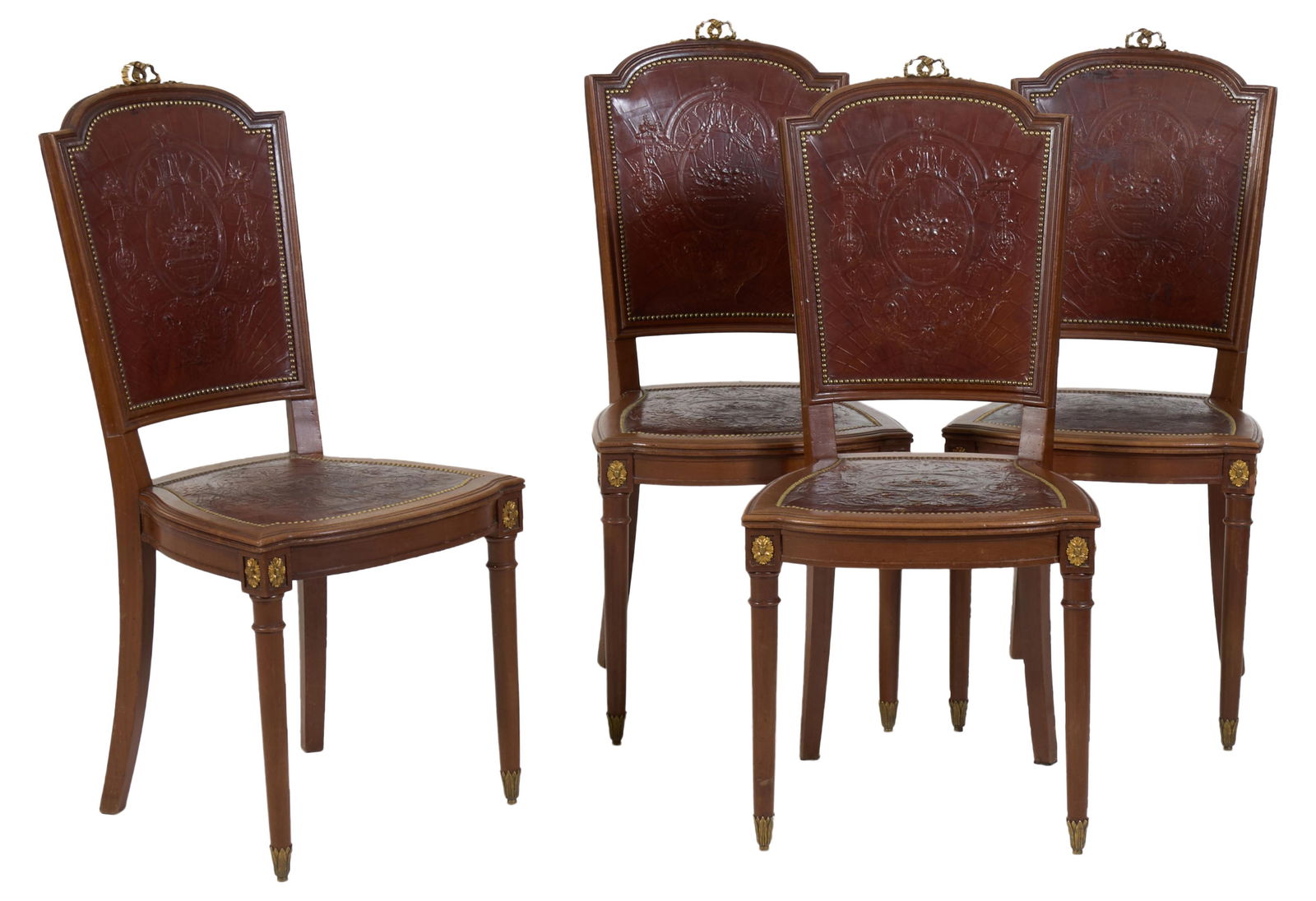 Four French Louis XVI Style Embossed Leather Side Chairs, early 20th c., H.- 39 in., W.- 17 in., D.-: Four French Louis XVI Style Embossed Leather Side Chairs, early 20th c., the brass bowknot mount over shield back with embossed leather upholstery, conforming seat, serpentine seat rail in to rosette