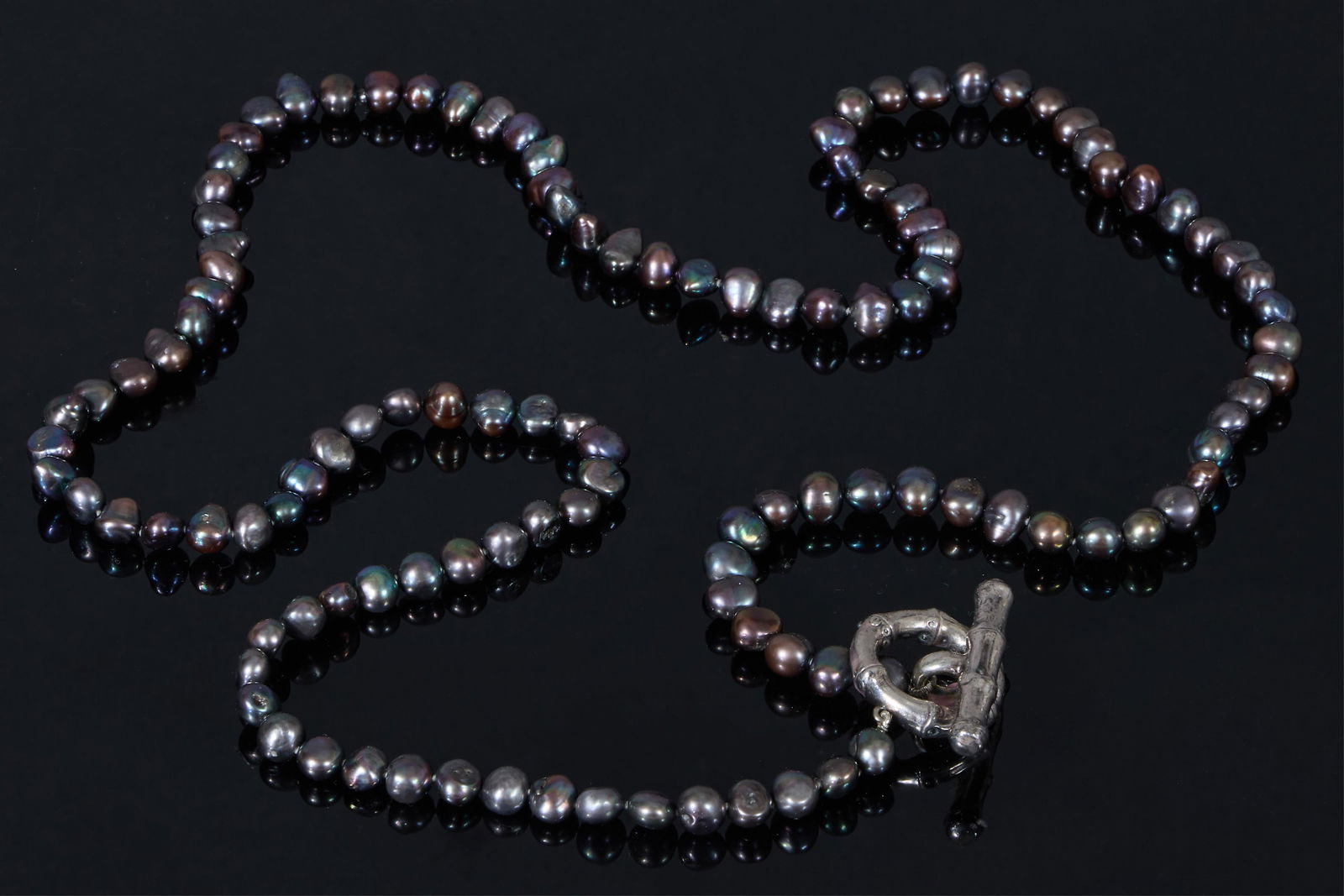 Strand of Japanese Black Pearls, L.- 44 in.: Strand of Japanese Black Pearls, consisting of 120 natural 10-12mm Tahitian pearls, with a sterling silver bamboo form toggle clasp, L.- 44 in. Please Note: All assessments of gemstone weight, color,