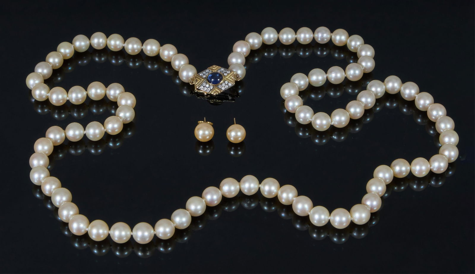 Three Piece White Pearl Jewelry Set, Strand- L.- 31 in. (3 Pcs.): Three Piece White Pearl Jewelry Set, consisting of a strand of 82 cultured 8mm golden pearls, the tension clasp mounted with a bezel set blue cabochon sapphire and 24 tiny round white diamonds; togeth