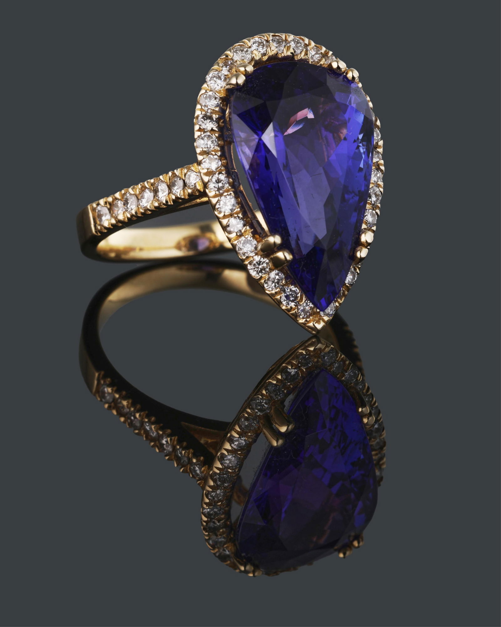 Ladies' 14K Yellow Gold Tanzanite and Diamond Dinner Ring, Total Diamond Wt.- 0.67 carats, Size- 6: Ladies' 14K Yellow Gold Tanzanite and Diamond Dinner Ring, the 8.69 carat pear shaped tanzanite a top a conforming border of small round white diamonds, with 7 small round white diamonds mounted on ea
