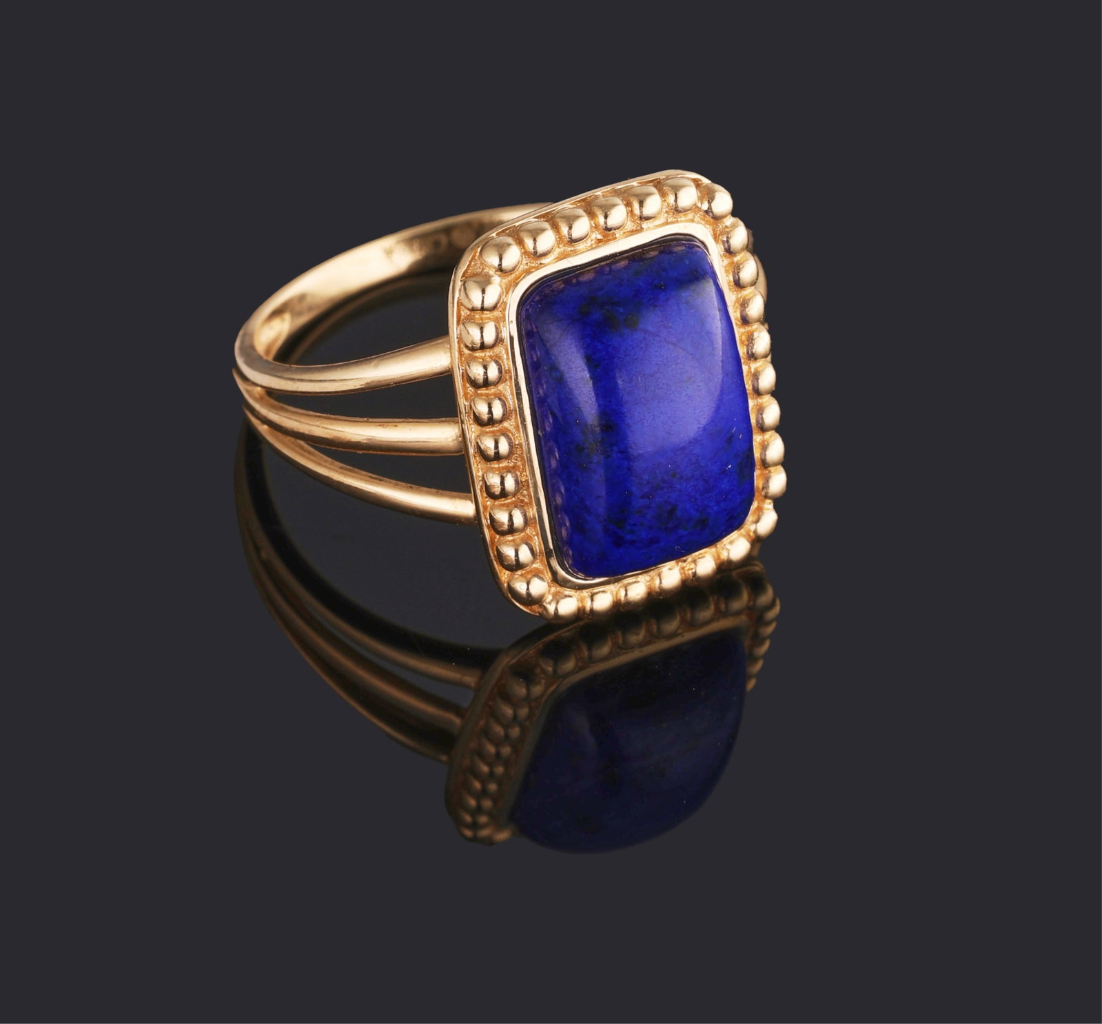 14K Yellow Gold Lapis Lazuli Ring, 20th c., Size- 8.: 14K Yellow Gold Lapis Lazuli Ring, 20th c., set with a rectangular cabochon lapis lazuli within a conforming border of gold beads, on a triple split band, Size- 8. Please Note: All assessments of gems