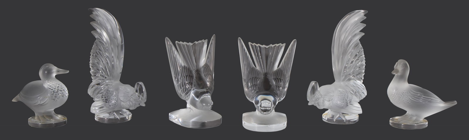 Six Lalique Bird Figures, 20th c., Roosters- H.- 8 7/8 in., W.- 2 3/4 in., D.- 5 in. (6 Pcs.): Six Lalique Bird Figures, 20th c., consisting of a pair of frosted glass ducks; a pair of frosted glass roosters; and a pair of frosted glass swallows, Roosters- H.- 8 7/8 in., W.- 2 3/4 in., D.- 5 in