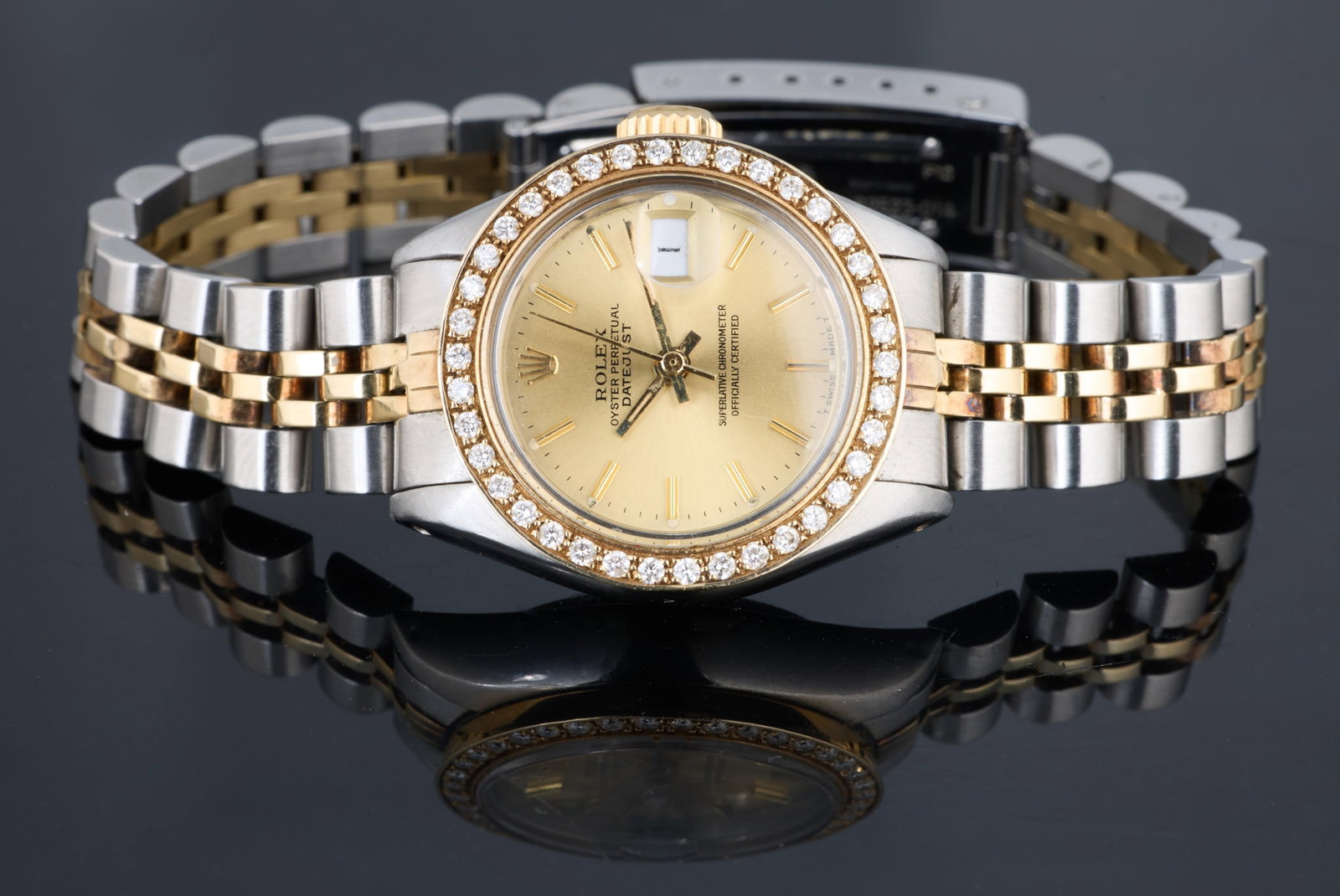 Lady’s Two Tone Rolex Datejust, Case- Dia.- 26 mm.: Lady’s Two Tone Rolex Datejust, in two-tone stainless steel and 18k yellow gold, custom diamond mounted bezel, Case- Dia.- 26 mm. Please Note: All assessments of gemstone weight, color, and/or clari