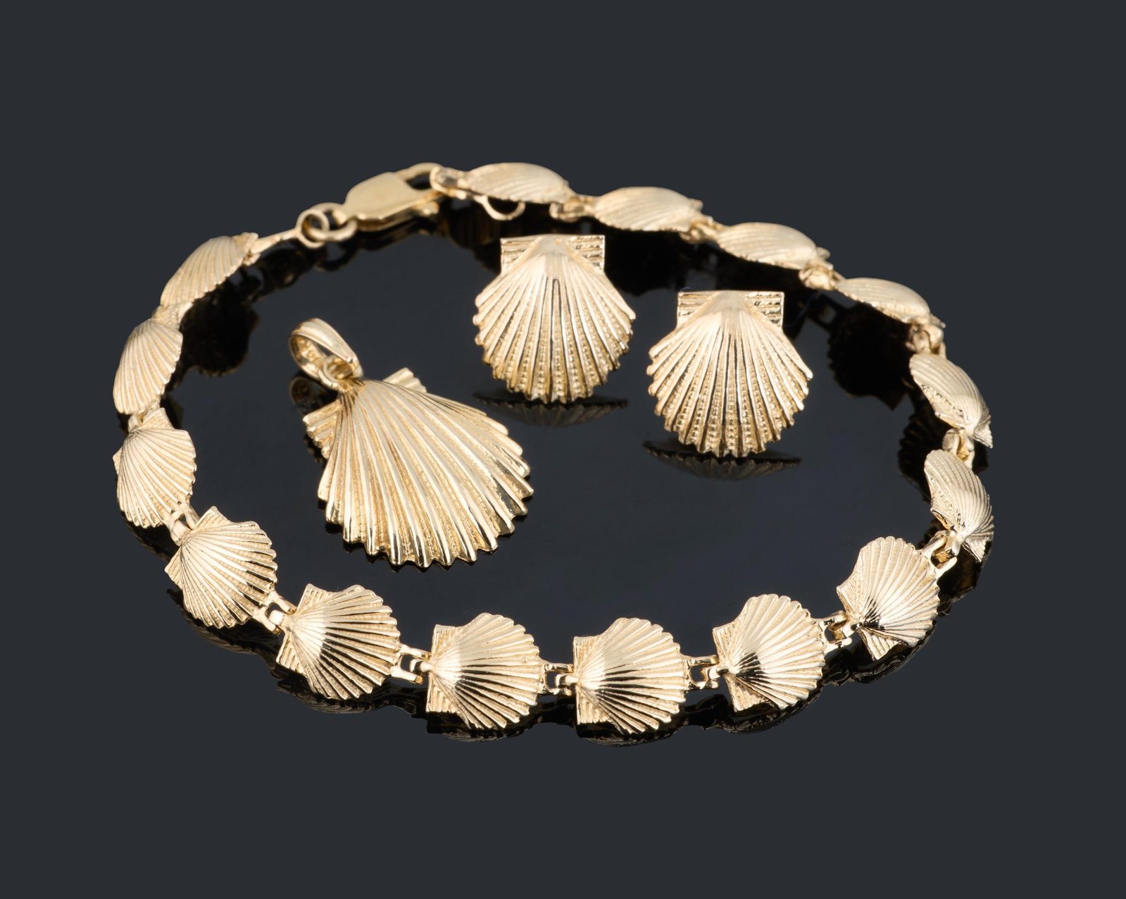 Four Piece Set of 14K Yellow Gold Jewelry, App. Total Wt.- 12.4 grams; Bracelet- L.- 7 in. (4 Pcs.): Four Piece Set of 14K Yellow Gold Jewelry, consisting of a bracelet, a pendant, and a pair of stud earrings, each of shell motif, App. Total Wt.- 12.4 grams; Bracelet- L.- 7 in. (4 Pcs.) Please Note: 