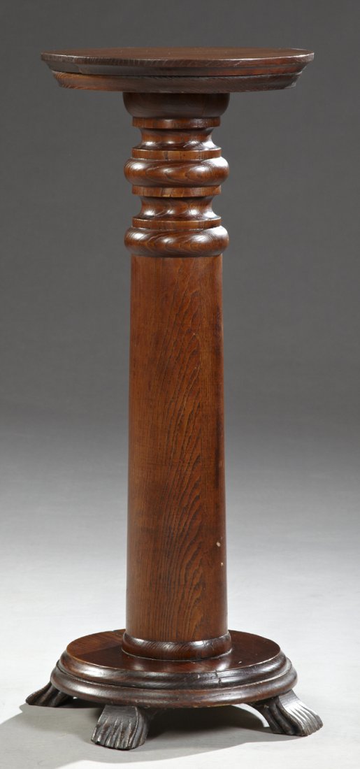 American Victorian Carved Oak Pedestal, c. 1900, the: American Victorian Carved Oak Pedestal, c. 1900, the stepped circular top on a turned support, to a stepped base, on four flat paw feet, H.- 34 1/2 in., Dia.- 17 1/2 in.