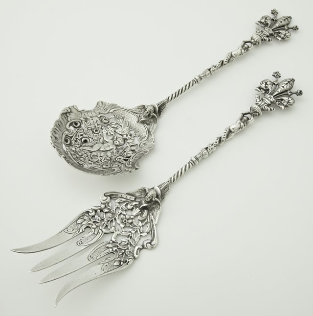 Pair of .800 Silver Salad Servers, early 20th c., the: Pair of .800 Silver Salad Servers, early 20th c., the terminals with relief prince of Wales feathers on relief nude supports to winged putto heads over the pierced spoon and fork, H.- 10 1/8 in., wt.-