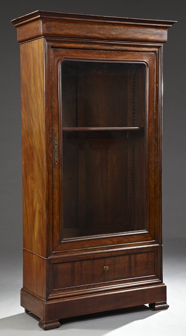 Louis Philippe Carved Mahogany Armoire, c. 1850, the: Louis Philippe Carved Mahogany Armoire, c. 1850, the stepped ogee crown over a glazed door, above a deep drawer and a bottom "secret" drawer, on stepped ogee block feet, now used as a bookcase, H.- 80